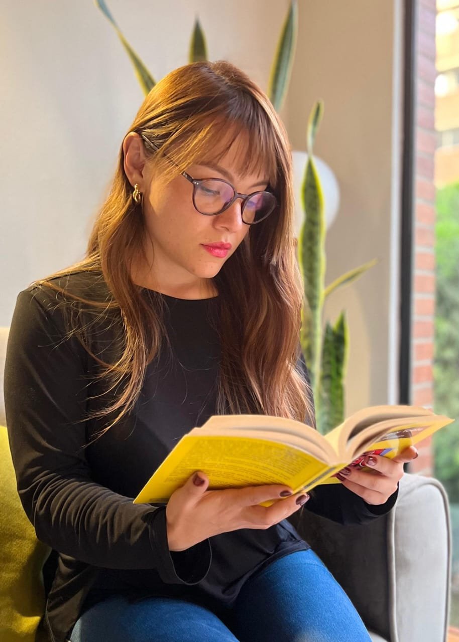 Angie leyendo en su espacio de trabajo